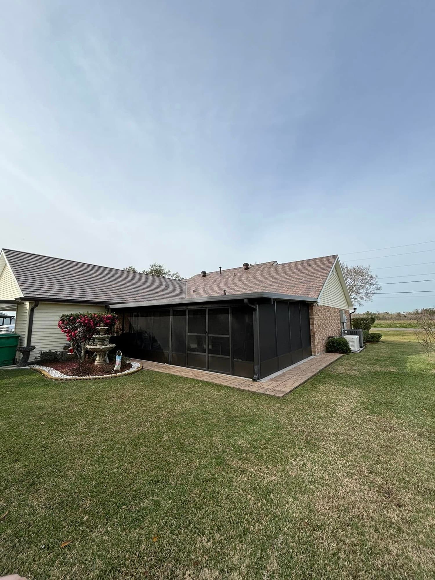 Screened patio addition on brick home in Raceland, LA — built by Foret Construction